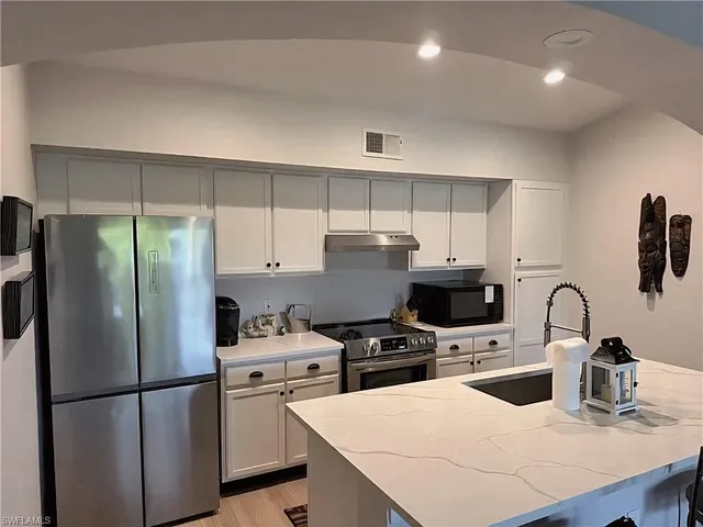 a kitchen with stainless steel appliances a refrigerator sink and cabinets
