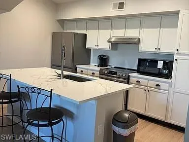 a kitchen with stainless steel appliances a stove a sink and a refrigerator