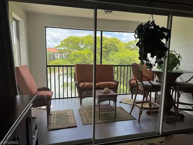 a living room with furniture and a floor to ceiling window
