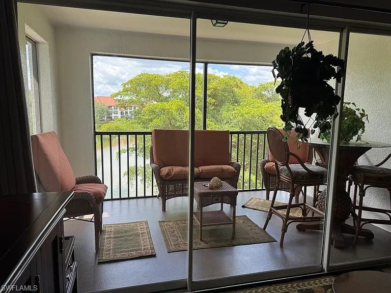 7905 Preserve Circle, Unit 138 Naples, FL 34119 - Photo 8 of 27 a living room with furniture and a floor to ceiling window
