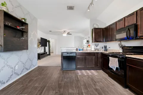 a kitchen with stainless steel appliances kitchen island granite countertop a stove a sink and a microwave