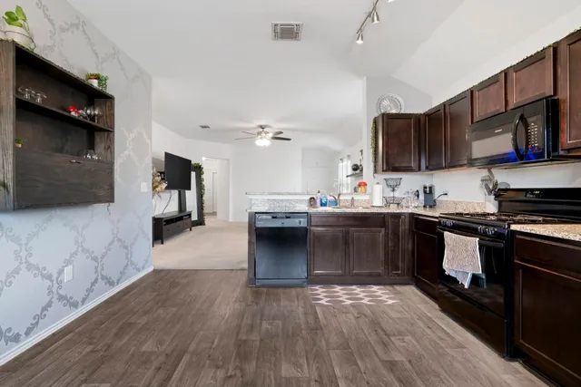 a kitchen with stainless steel appliances kitchen island granite countertop a stove a sink and a microwave