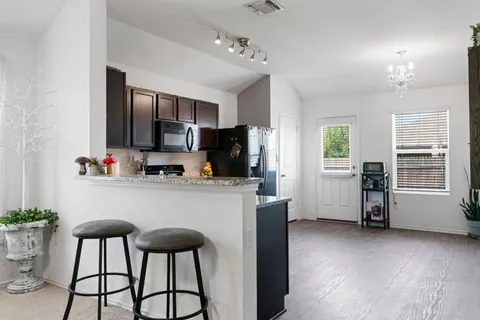 a kitchen with stainless steel appliances kitchen island granite countertop a refrigerator and microwave