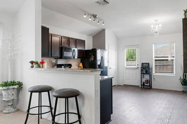 a kitchen with stainless steel appliances kitchen island granite countertop a refrigerator and microwave