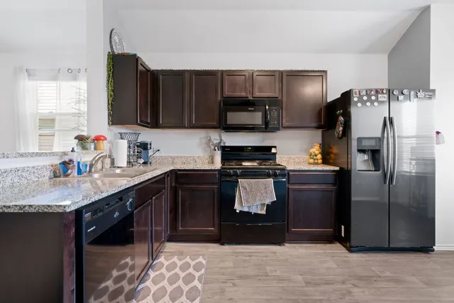 a kitchen with stainless steel appliances granite countertop a refrigerator and a sink