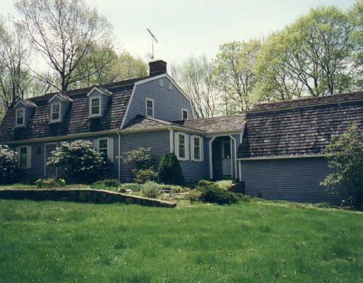 a front view of a house with a garden and plants