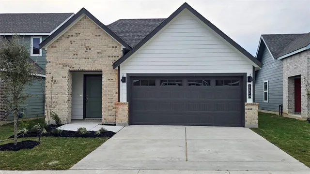 a front view of a house with a garden and garage