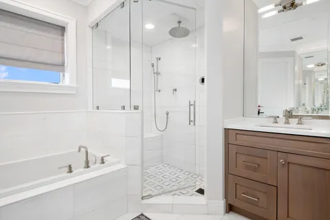 a bathroom with a tub sink shower and mirror