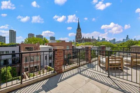 a view of a balcony with two chairs and a potted plant