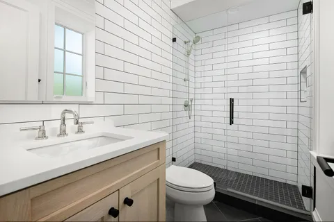 a bathroom with a sink a toilet and shower