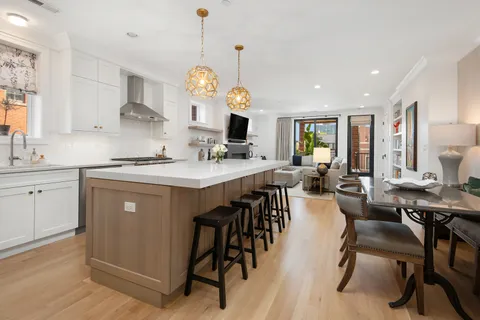 a kitchen with a table chairs sink and cabinets