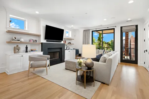 a living room with furniture a flat screen tv and a fireplace