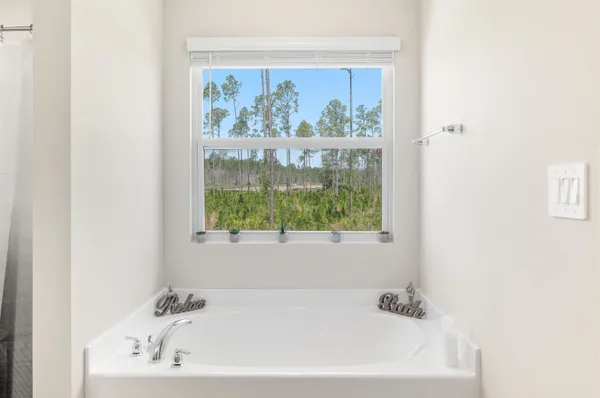a white bath tub sitting in a bathroom next to a window