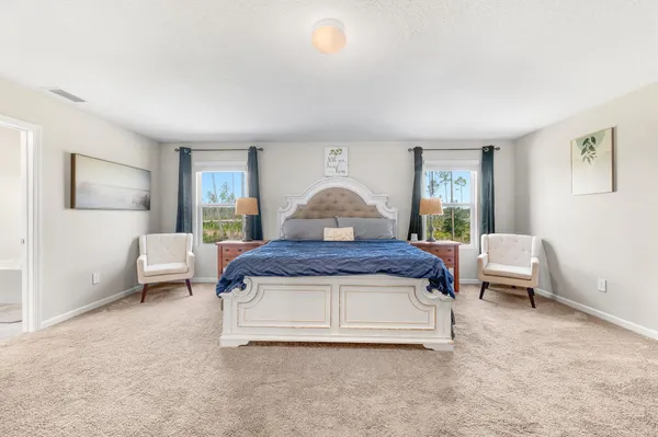 a spacious bedroom with a bed and a couch