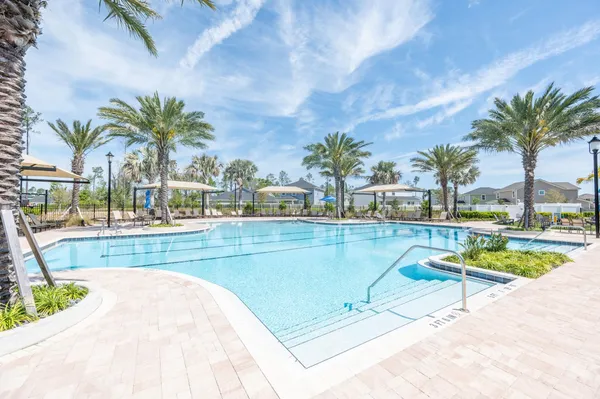 a view of swimming pool with outdoor seating and house in the background