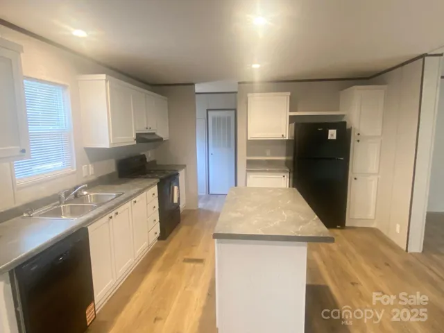a kitchen with a sink a refrigerator and cabinets