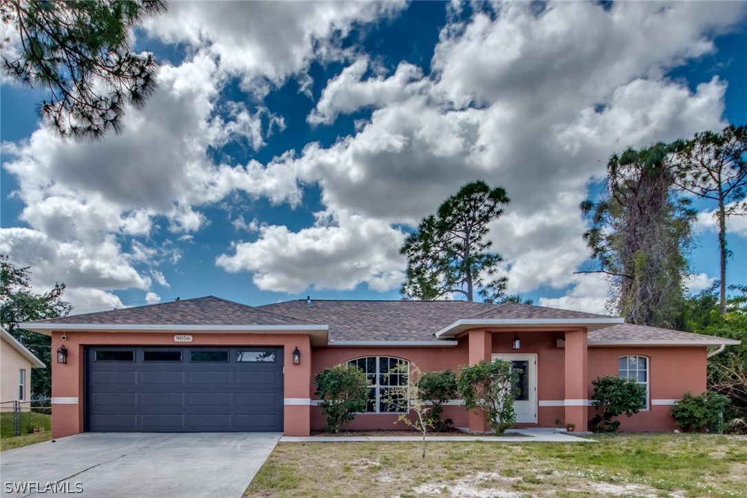 9056 Aster Road Fort Myers, FL 33967 - Photo 1 of 6 a front view of a house with garden