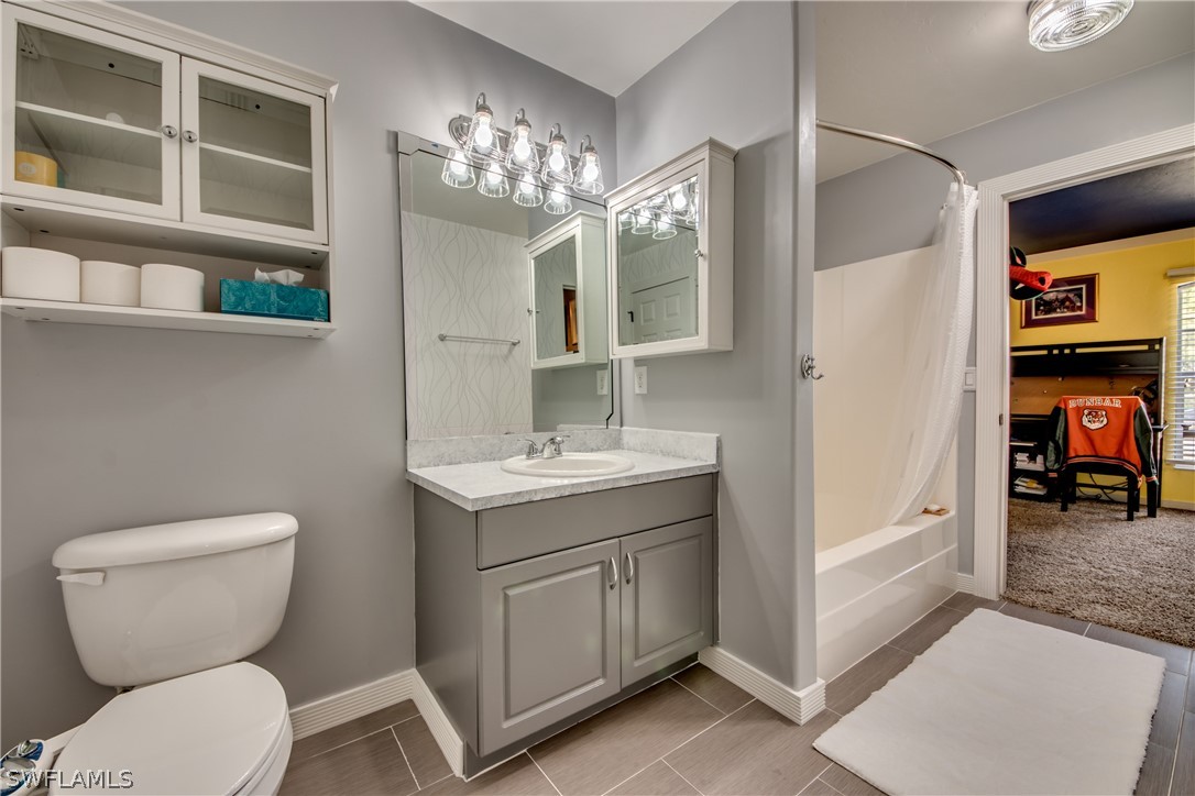9056 Aster Road Fort Myers, FL 33967 - Photo 4 of 6 a bathroom with a toilet a sink and mirror