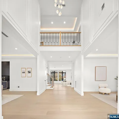 a kitchen with stainless steel appliances granite countertop a stove a refrigerator a sink a dining table and chairs