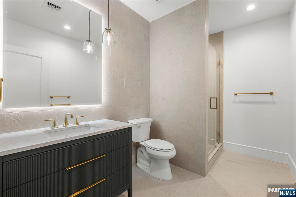 375 Burnet Place Paramus, NJ 07652 - Photo 32 of 37 a bathroom with a toilet a sink and mirror