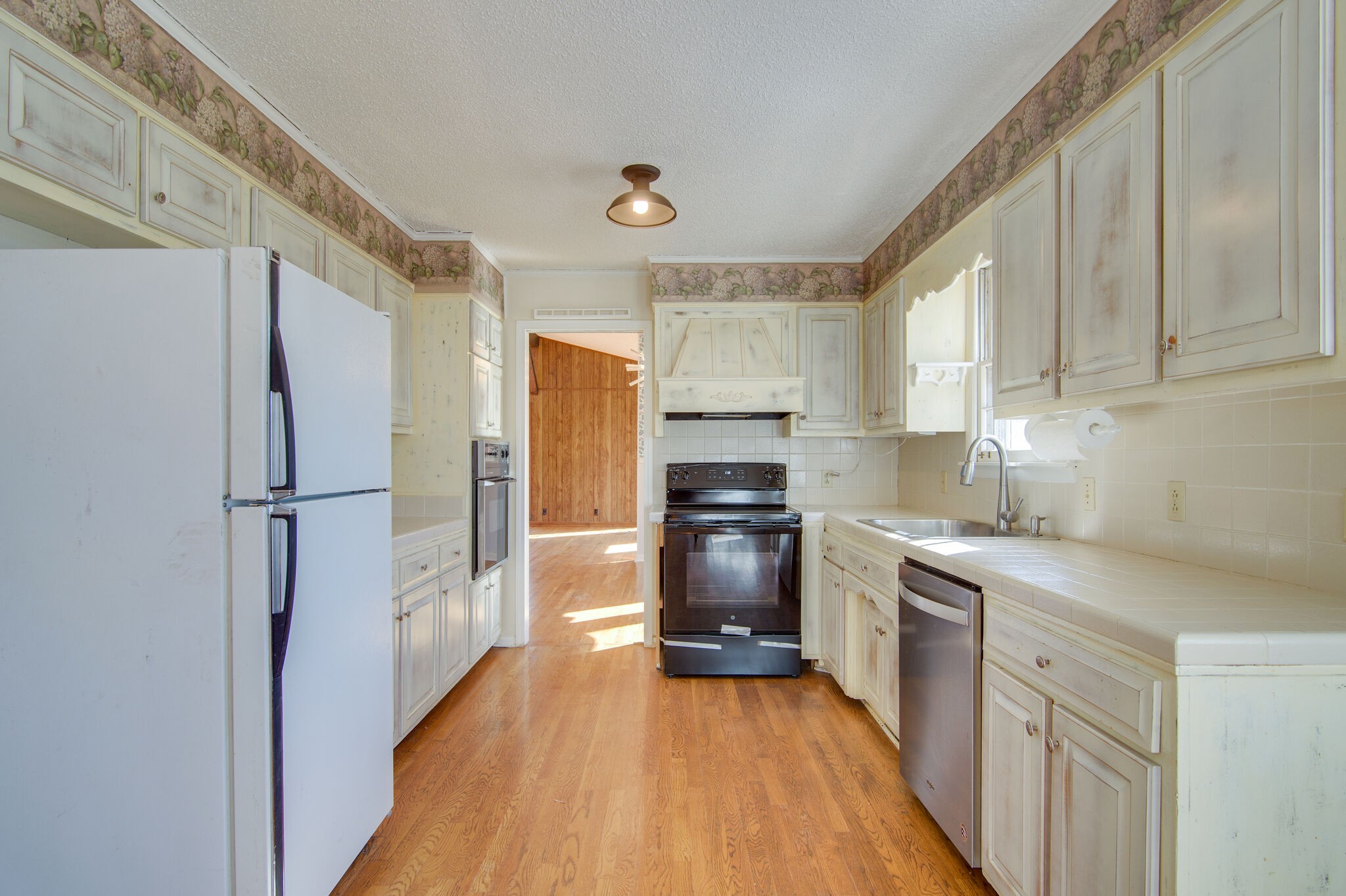 7325 Overby Road Fairview, TN 37062 - Photo 16 of 49 a kitchen with a refrigerator a sink dishwasher and a stove top oven with wooden floor