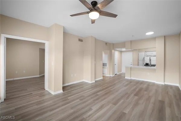a view of empty room with wooden floor