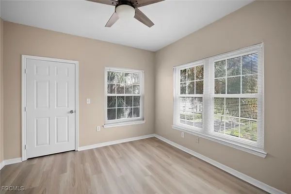 a view of an empty room with a window and wooden floor