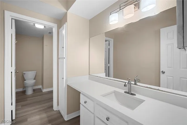 a bathroom with a sink and a mirror with toilet