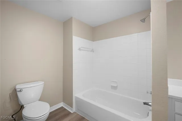 a white toilet sitting next to a bath tub