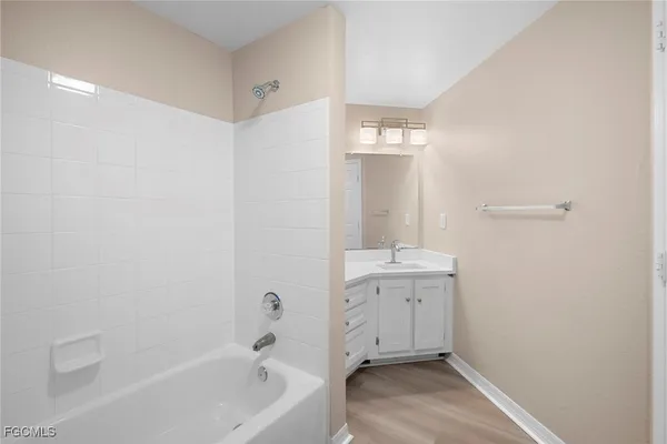 a bathroom with a tub sink and mirror