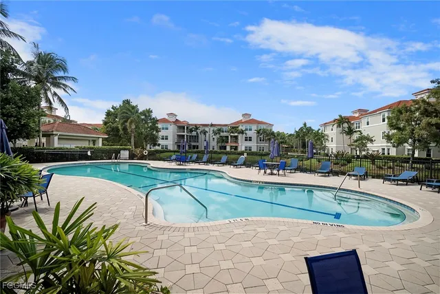 a view of a swimming pool with a lounge chair and palm trees