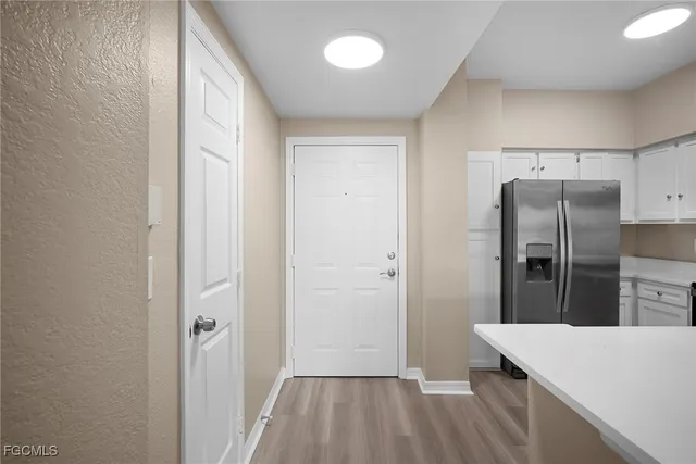 a kitchen with a refrigerator and wooden floor
