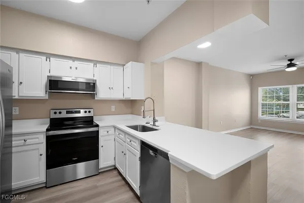 a kitchen with stainless steel appliances a stove a sink and a microwave