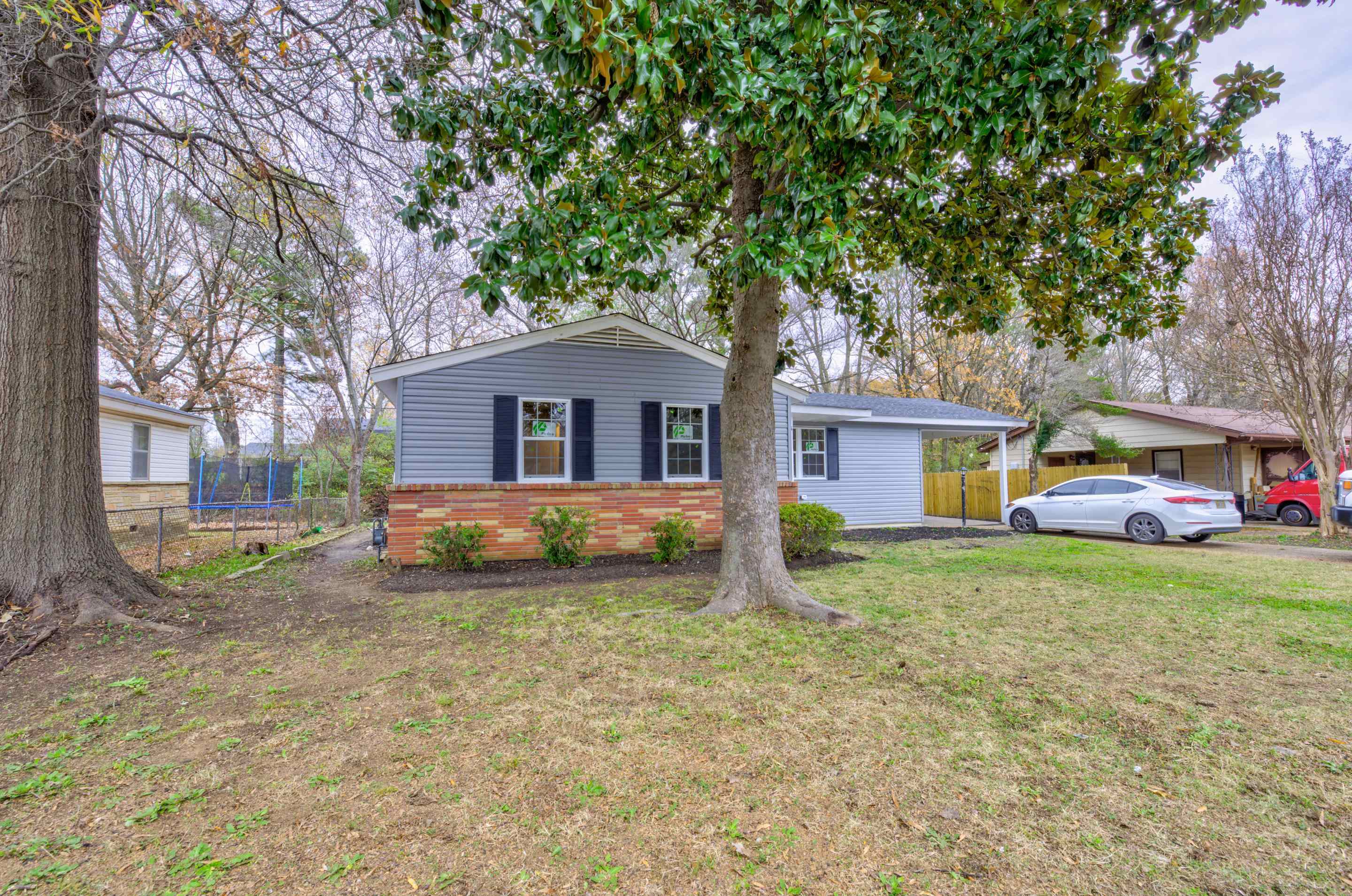 5546 Millbranch Road Memphis, TN 38116 - Photo 2 of 24 a front view of a house with a yard and trees