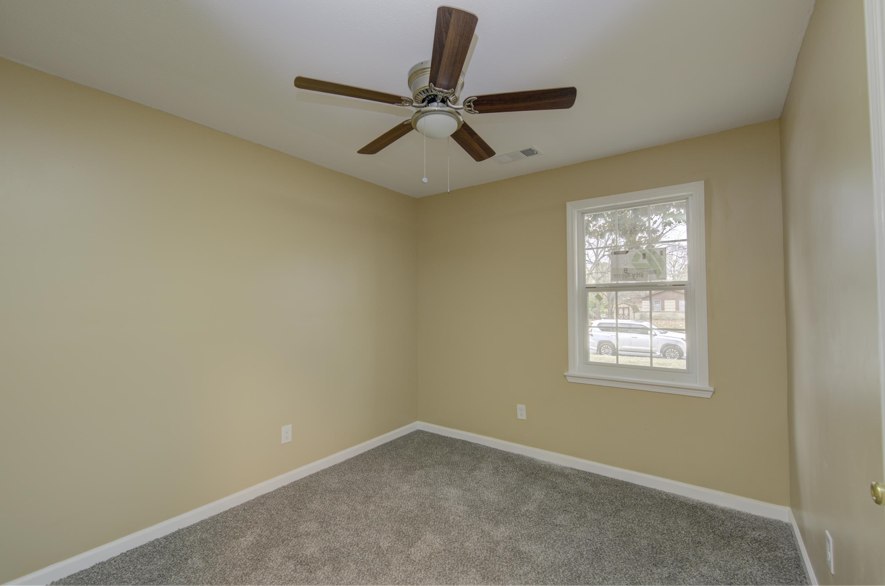 5546 Millbranch Road Memphis, TN 38116 - Photo 15 of 24 an empty room with a window and a fan