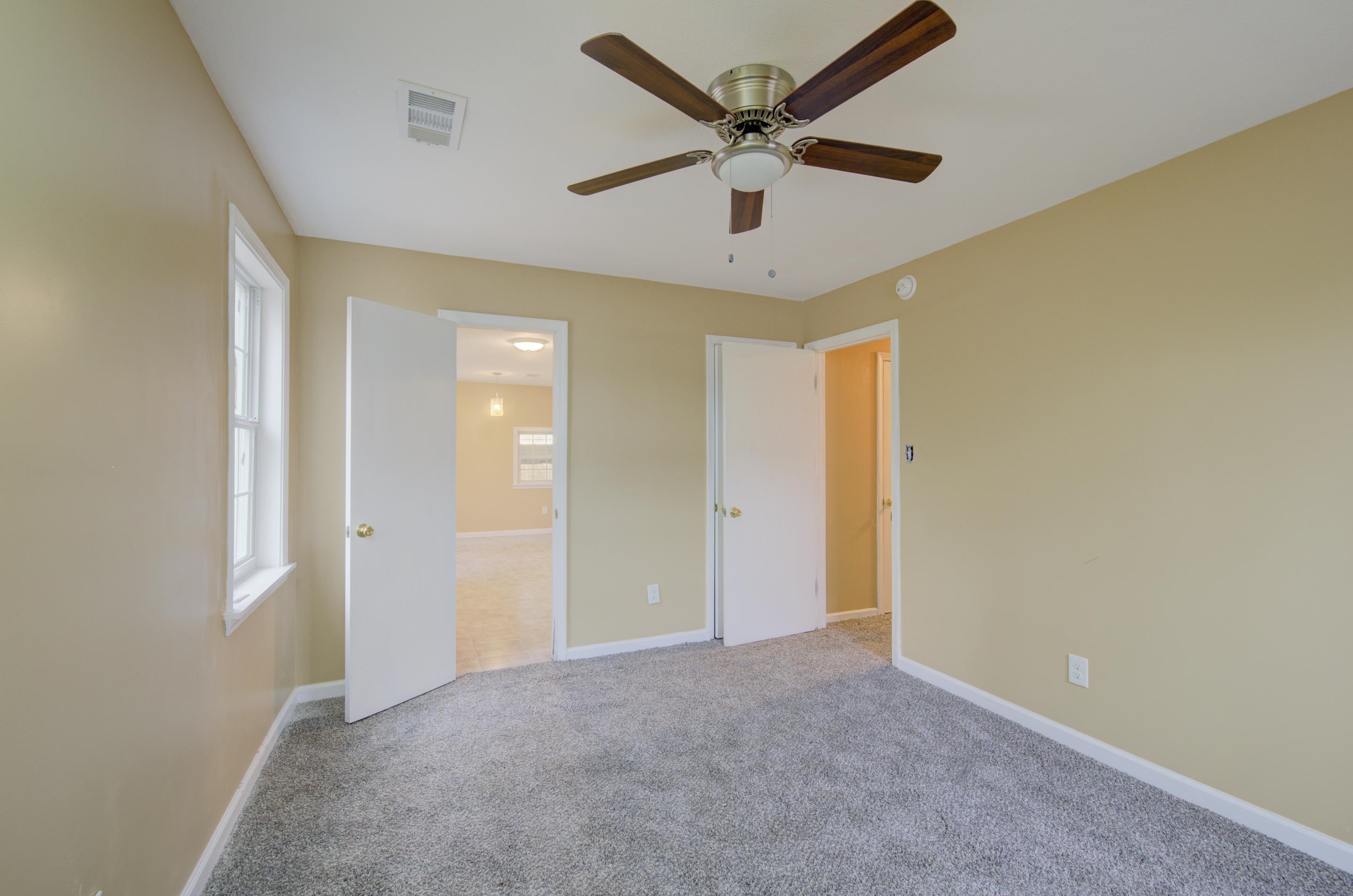 5546 Millbranch Road Memphis, TN 38116 - Photo 19 of 24 an empty room with a ceiling fan and a window