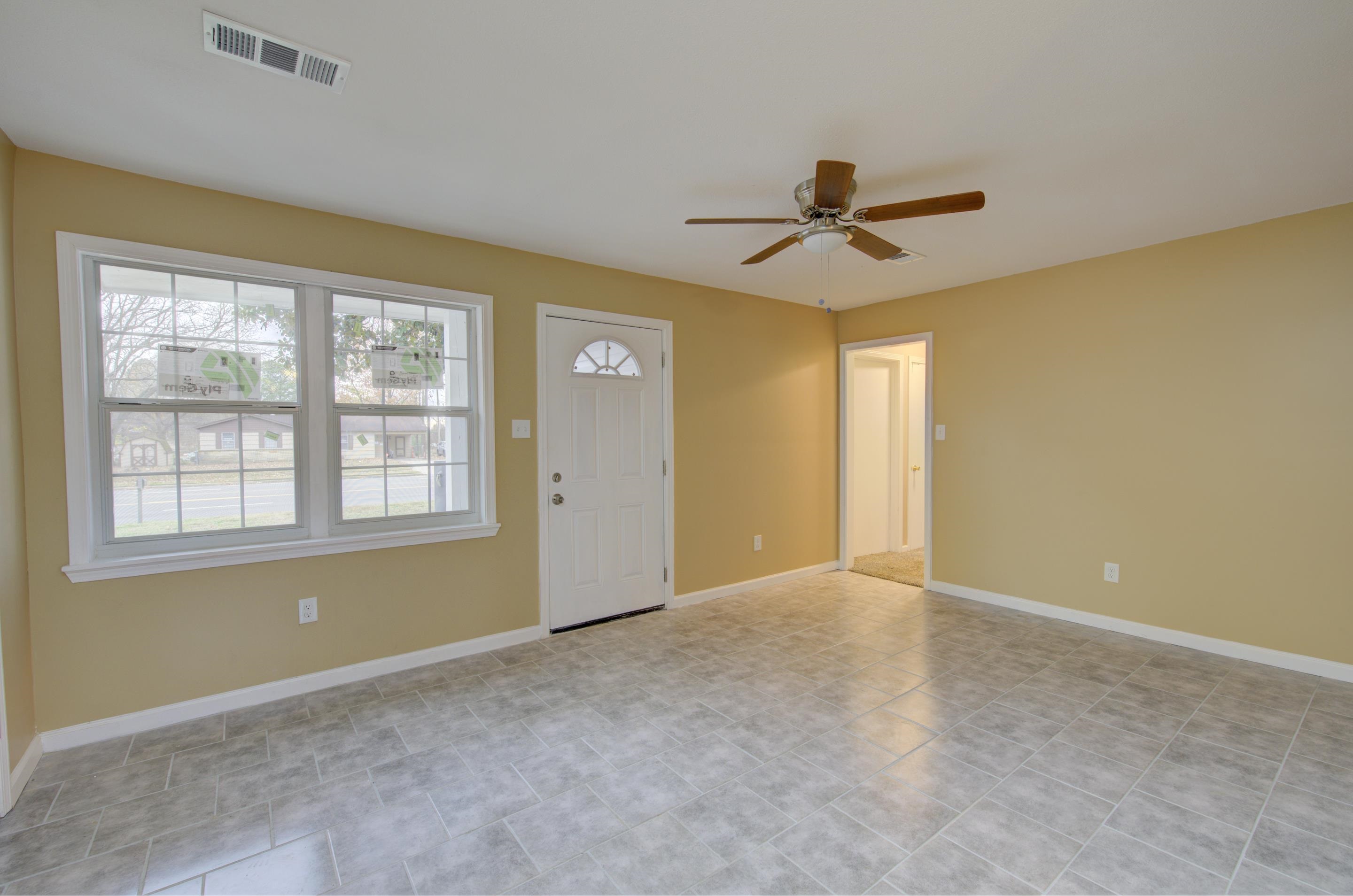 5546 Millbranch Road Memphis, TN 38116 - Photo 6 of 24 an empty room with windows and fan