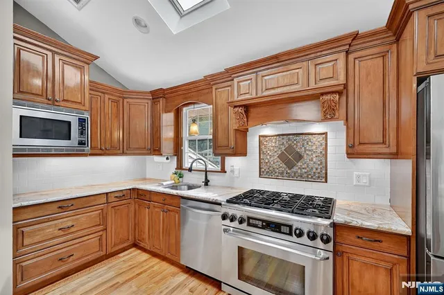 a kitchen with granite countertop cabinets stainless steel appliances and wooden floor