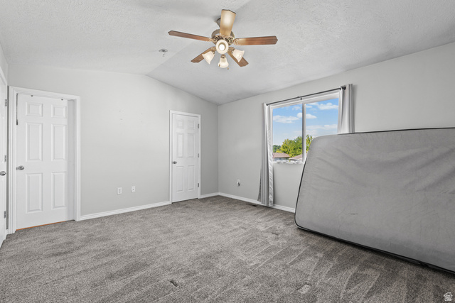 652 West 800 North, Unit 45 Clinton, UT 84015 - Photo 15 of 17 Vaulted ceiling room featuring light gray carpeting, twin pane windows with gray curtains, and a ceiling fan with light fixture
