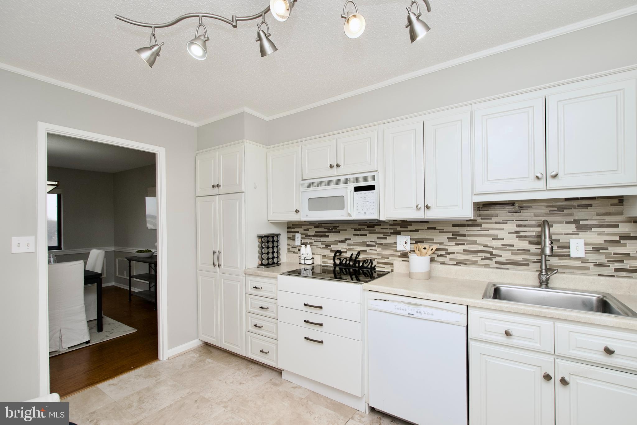 5902 Mt Eagle Drive, Unit 905 Alexandria, VA 22303 - Photo 12 of 55 a kitchen with granite countertop white cabinets and white appliances