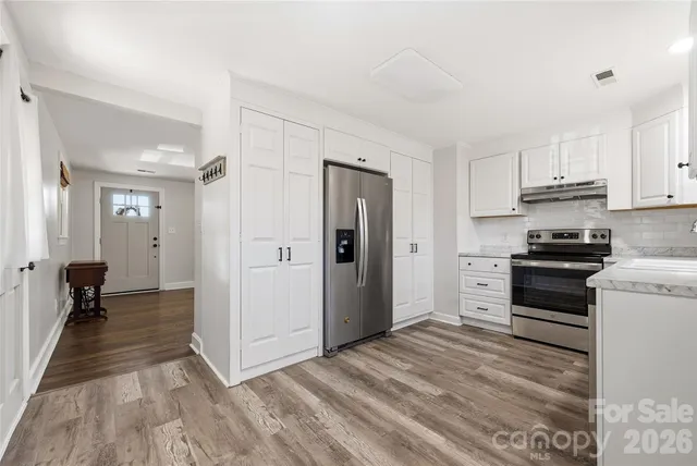 a kitchen with a refrigerator and a stove top oven