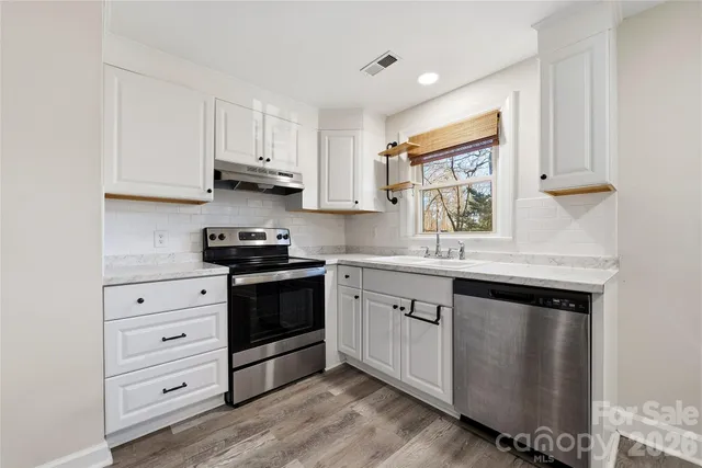 a kitchen with granite countertop white cabinets and white appliances