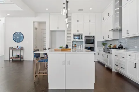 a kitchen with white cabinets and refrigerator