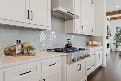 a kitchen with stainless steel appliances granite countertop a sink a stove and cabinets