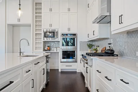 a kitchen with stainless steel appliances white cabinets and a stove