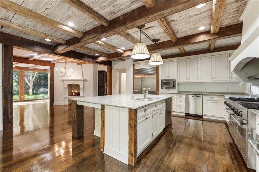2485 West Wesley Road Northwest Atlanta, GA 30327 - Photo 28 of 84 a large kitchen with stainless steel appliances granite countertop a large stove a sink dishwasher and white cabinets with wooden floor