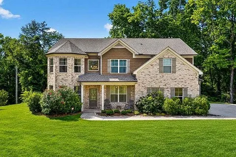a front view of a house with a yard and potted plants