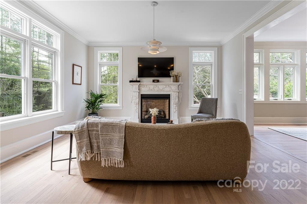 343 Vanderbilt Road Asheville, NC 28803 - Photo 15 of 48 a living room with furniture a large window and a fireplace