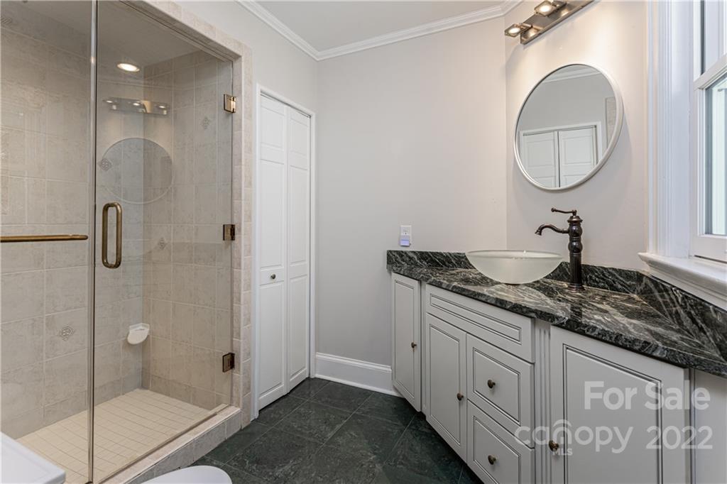 343 Vanderbilt Road Asheville, NC 28803 - Photo 30 of 48 a bathroom with a granite countertop sink a mirror and shower