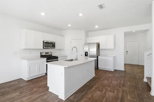 a kitchen that has a sink and a stove top oven